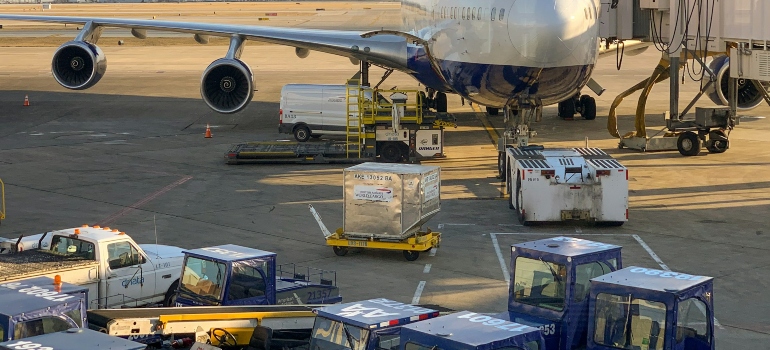 Plane loading cargo for moving abroad on a budget.