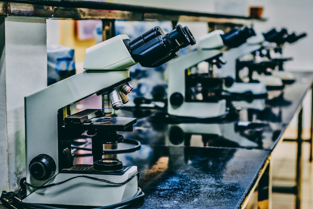 Several white microscopes on top of black table