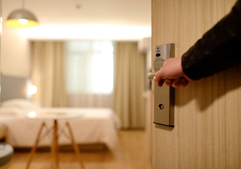 Person opening the doors to a hotel room.