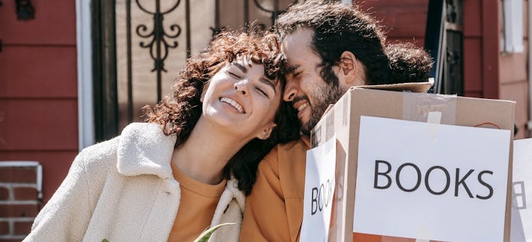 A Happy Couple Carrying Boxes