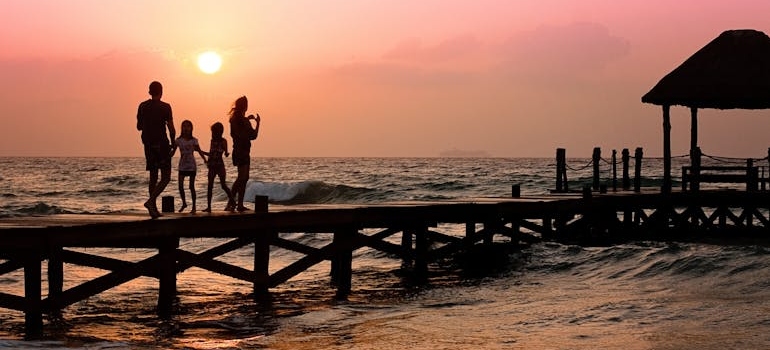 A family standing on a pier during sunset