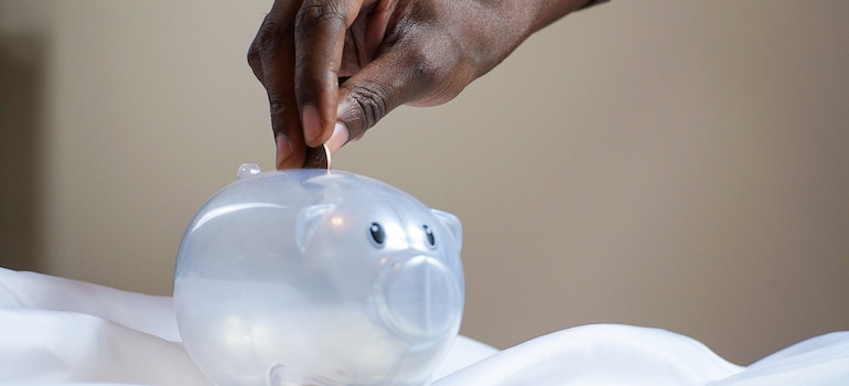 person putting money into piggy bank