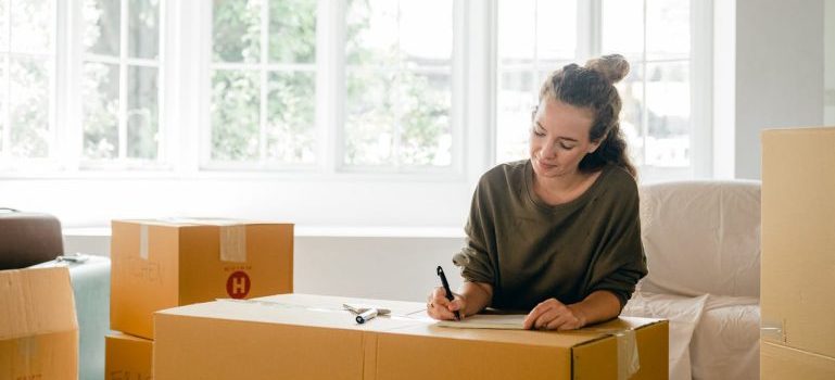 a woman writing her international moving checklist.