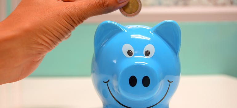 Person putting coin in a piggy bank