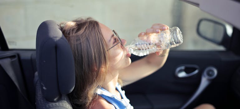 a woman drinking water on a hot summer day